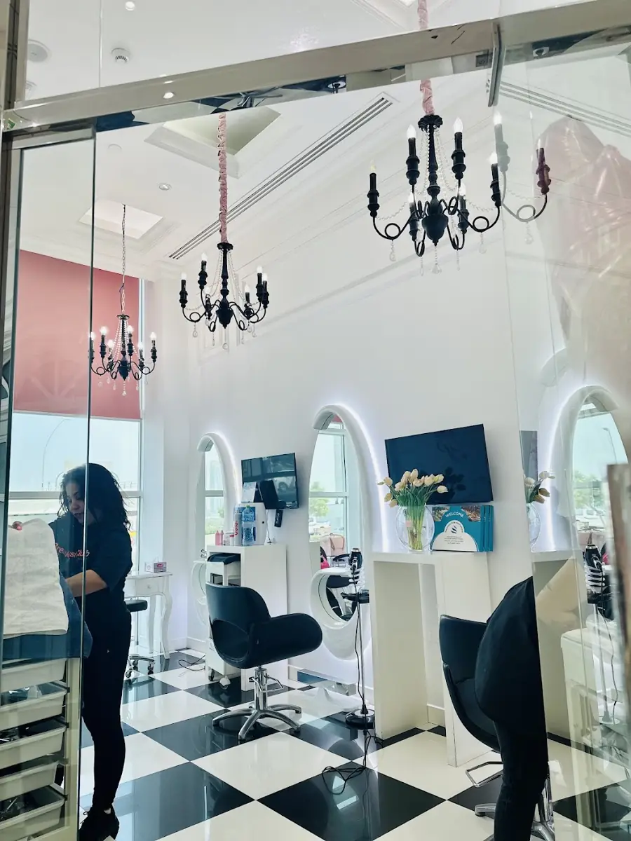 Salon chairs under chandeliers and arched mirrors