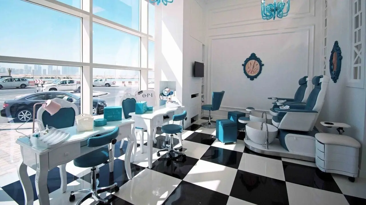 Manicure stations with teal chairs by the windows